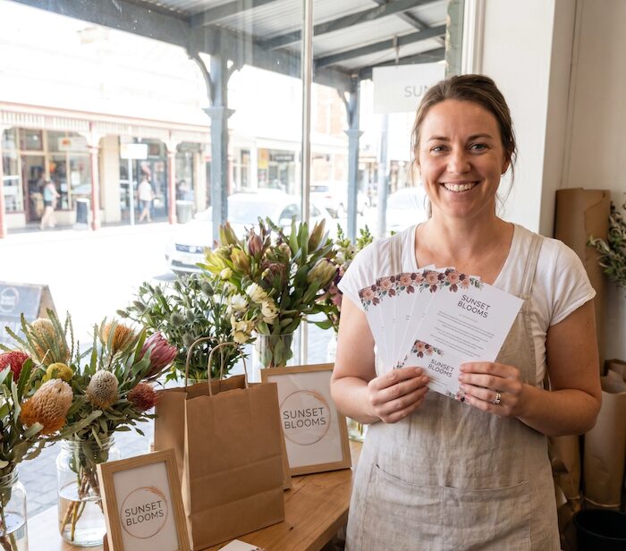 Perth florist holding printed flyers and business cards for local print marketing